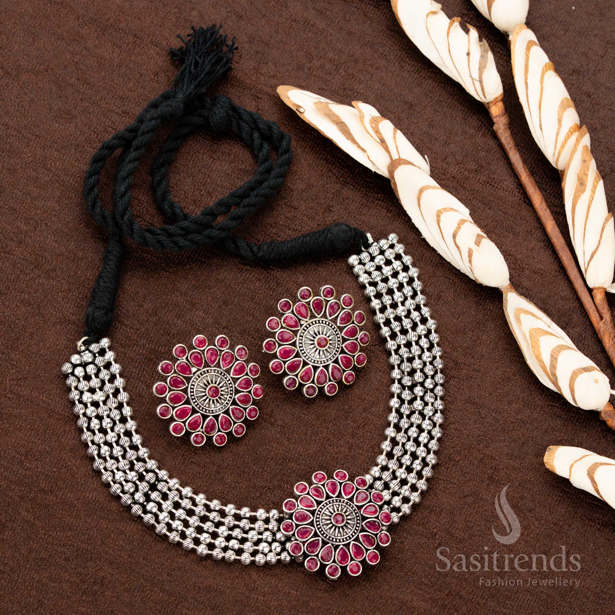 Handcrafted oxidised German silver choker set with a stunning floral pendant and rich ruby stones, styled with four-strand beads, ideal for Navaratri, weddings, and grand festive occasions - Sasitrends