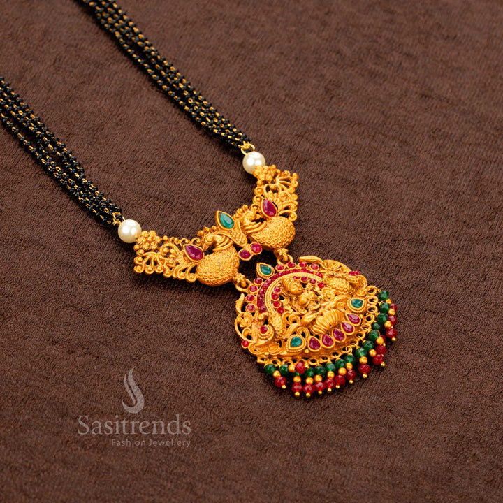 Divine and traditional matte gold necklace set adorned with Lakshmi and peacock designs, complemented by ruby-green jhumkas—an iconic festive temple jewellery masterpiece with timeless charm and spiritual flair - Sasitrends