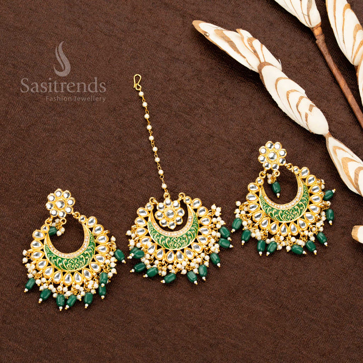 Majestic gold plated tikka and earrings set, featuring emerald green hand-painted details, decorative stone work, and pearl bead drops - Sasitrends