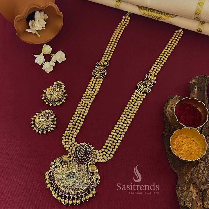Royal bridal temple matte gold tone long jewellery set featuring dual pendant and ruby-green embellishments, paired with intricately carved jhumka earrings for traditional festivities – Sasitrends