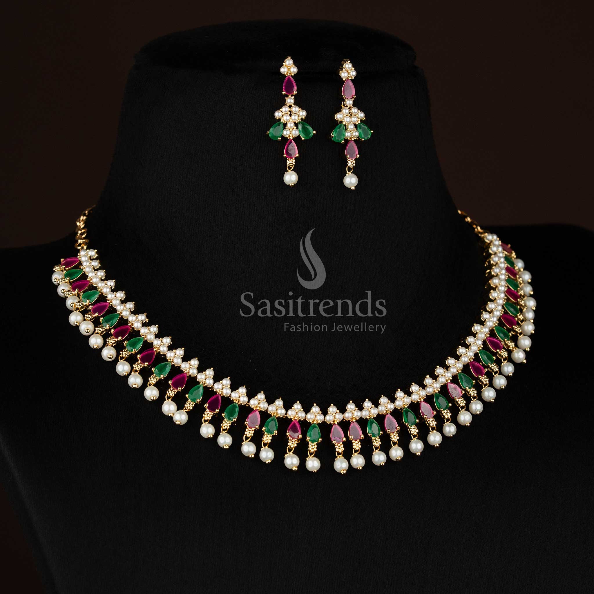 Crest designed micro gold plated pearl ruby green triangle cut teardrop American diamond necklace set finished with pearl drops for festive wear - Sasitrends