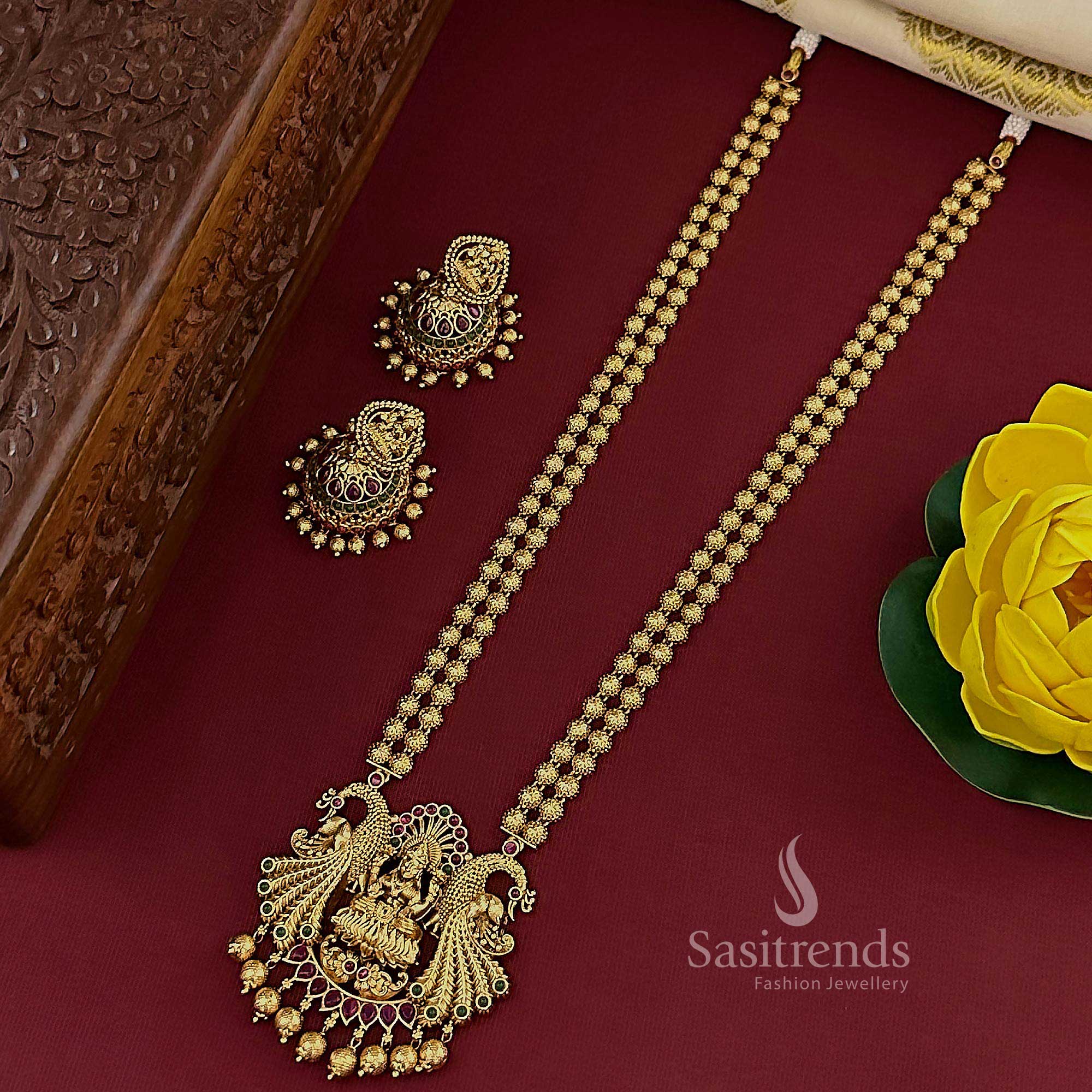 Elegant ruby-green temple matte gold plated double-layered long jewellery set showcasing an exquisite Lakshmi peacock pendant and cultural jhumkas, designed for timeless bridal celebrations – Sasitrends