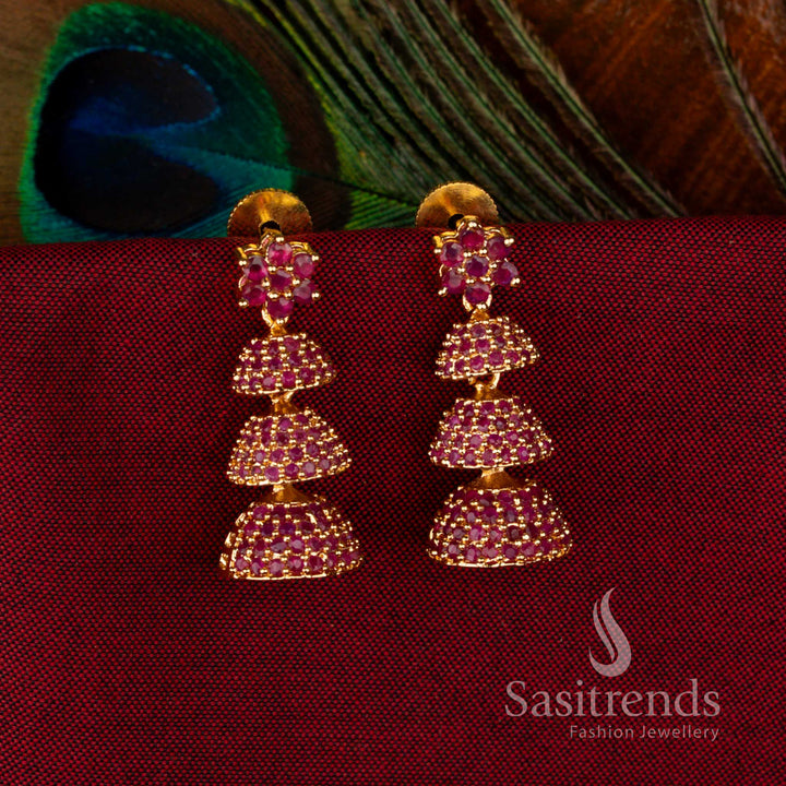 Statement Gold Plated Brass Triple-Layer Jhumkas with Rich Ruby American Diamond Accents, Temple-Inspired Design for Bridal and Party Wear – Sasitrends