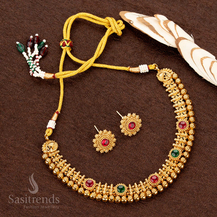 Heritage-style antique gold necklace set embellished with ruby and green stones, opulent beaded layers, and intricate motifs, making it an elegant choice for bridal wear - Sasitrends