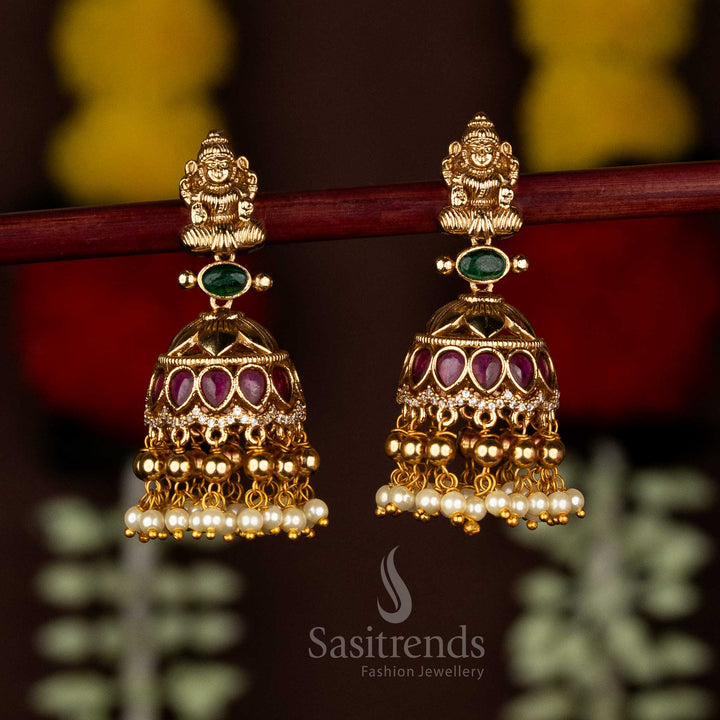Majestic Matte Gold Plated AD Stone Temple Lakshmi Jhumka with Bead & Pearl Drops For Festive Wear