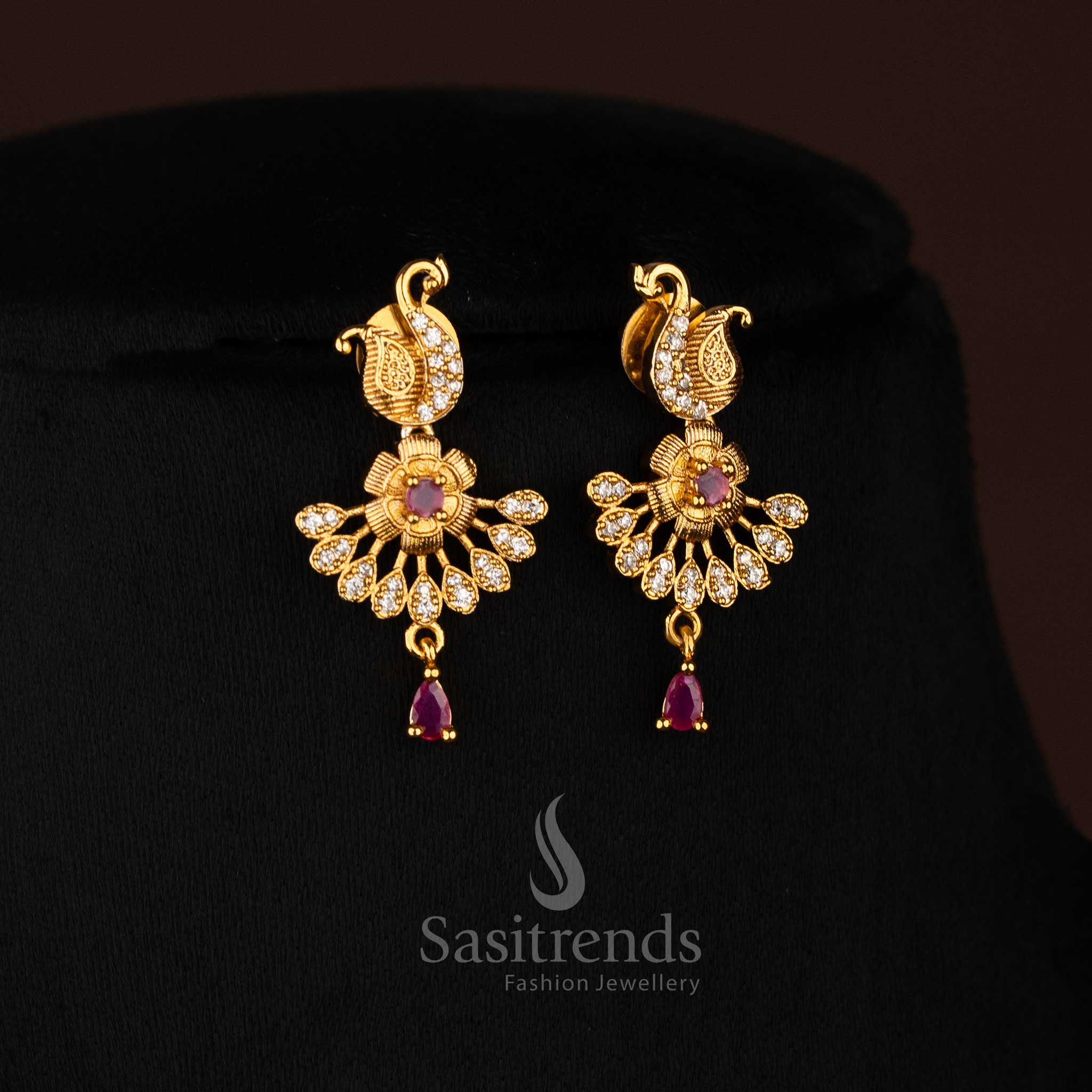 Royal matte gold peacock motif earrings embellished with sparkling white and ruby stones, paired with graceful floral accents for an opulent traditional jewellery finish ideal for weddings and festive celebrations – Sasitrends