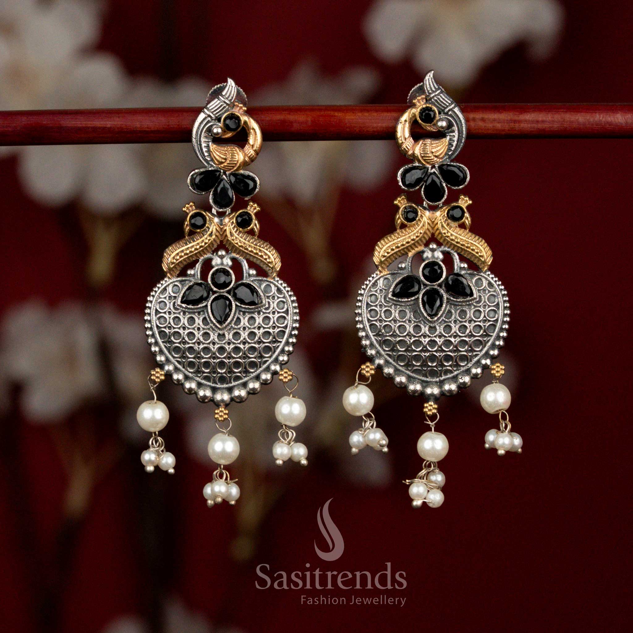 Bold antique oxidised silver earrings featuring black Monalisa stones, sculpted peacock heart design and clustered pearl drops for statement festive wear - Sasitrends
