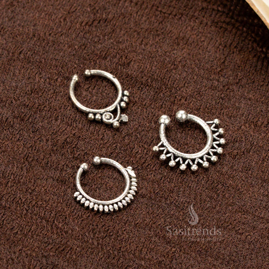Vintage-inspired oxidised pressable nosepin set with tribal star, lotus, and bell motifs, crafted in silver-look finish with ethnic glam and handcrafted finesse by Sasitrends