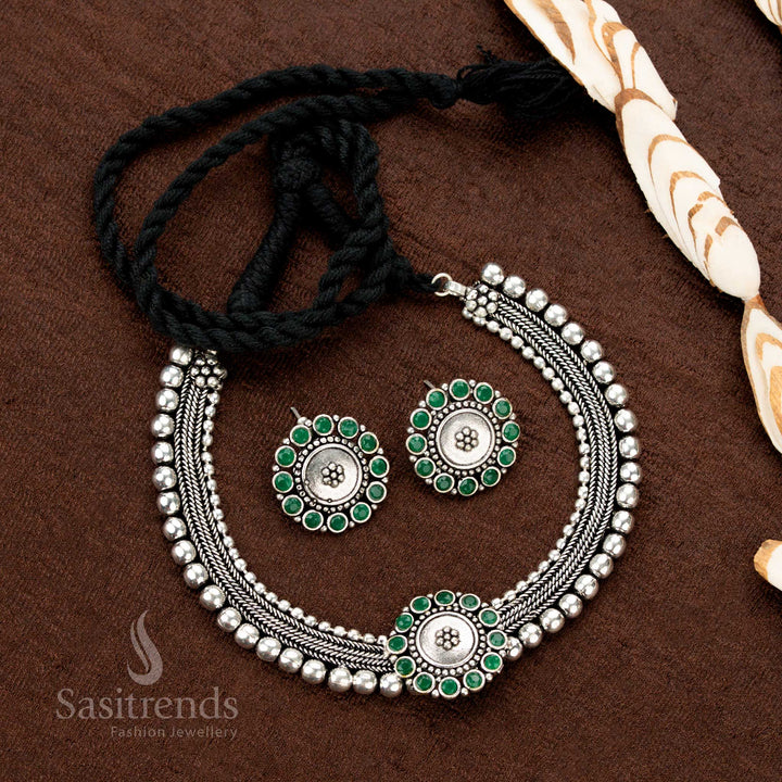 Exquisite Kolapuri choker jewellery set with moss emerald green floral stones in an oxidised silver and gold dual-tone style, perfect for traditional events, sarees, and festive wear - Sasitrends
