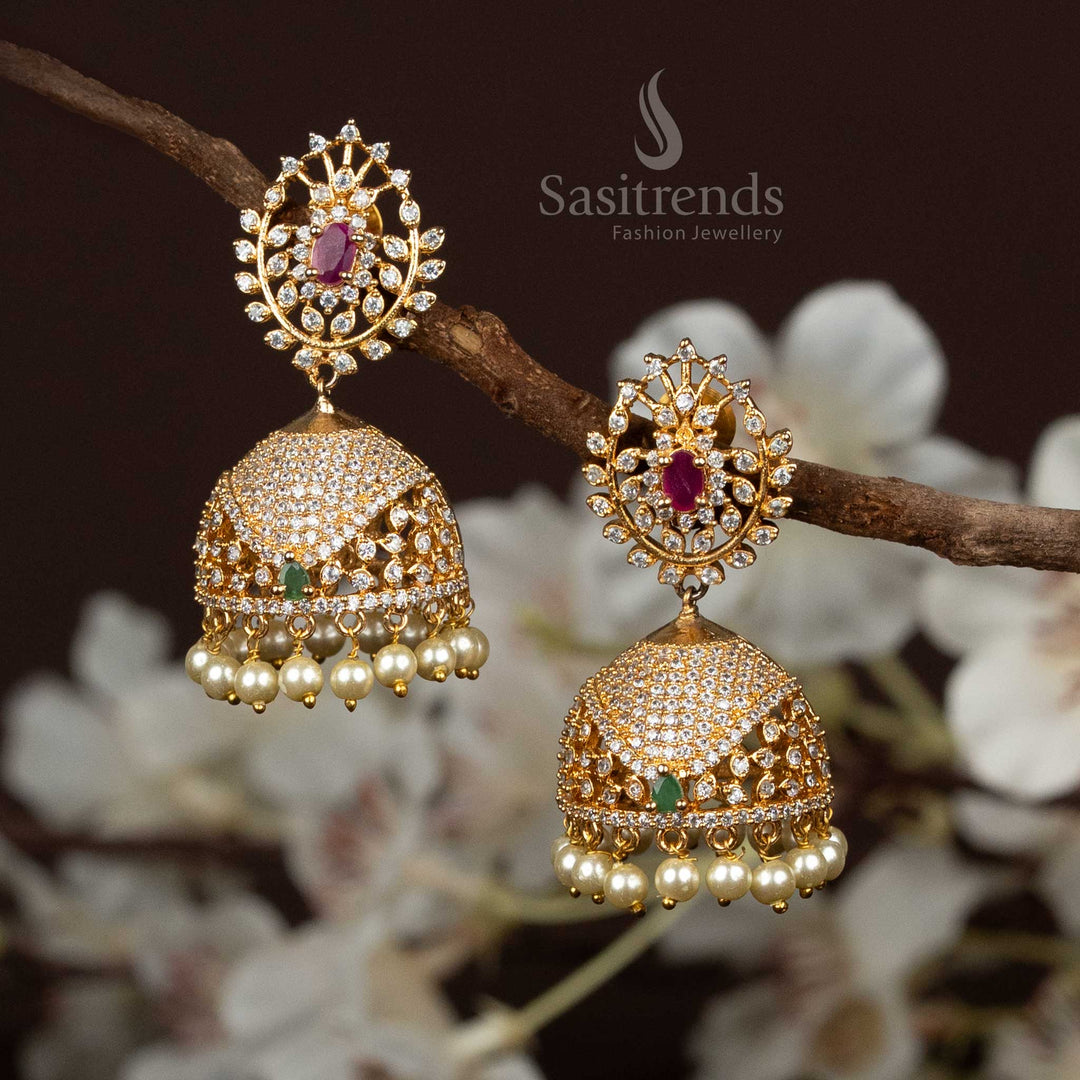 Regal gold plated floral dome Jhumka earrings adorned with shimmering American diamonds and dainty pearl drops – a refined blend of sparkle and grace – Sasitrends