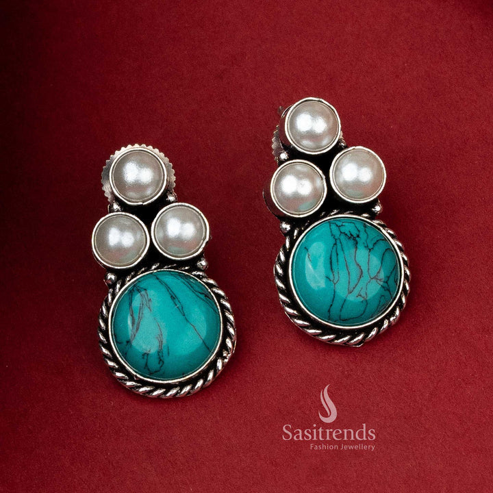 Oxidized silver earrings with a turquoise monalisa stone offering a pop of color, flanked by pearls for a classic look