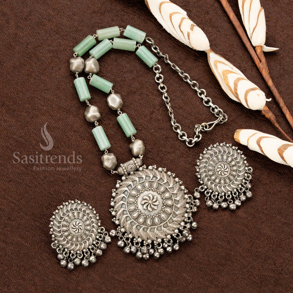 Grand oxidised floral necklace, adorned with delicate mint stones, an ornate round pendant, and detailed matching earrings, embodying a vintage aesthetic, perfect Navaratri jewellery - Sasitrends