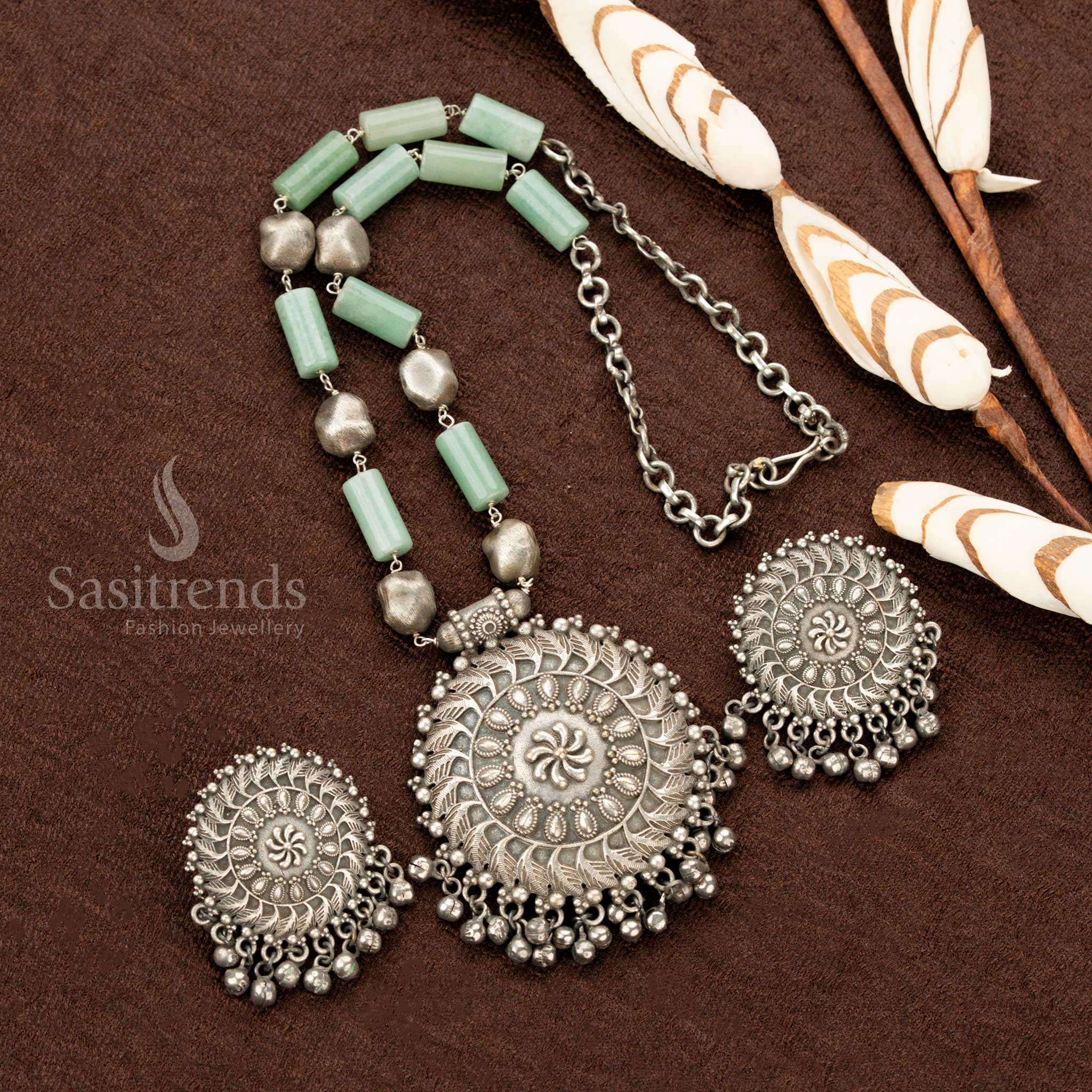 Grand oxidised floral necklace, adorned with delicate mint stones, an ornate round pendant, and detailed matching earrings, embodying a vintage aesthetic, perfect Navaratri jewellery - Sasitrends