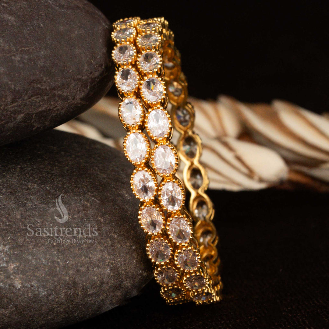 Micro gold plated white American diamond stone bangles with oval-shaped designs – a classy ethnic jewellery style suited for bridal and graceful party wear by Sasitrends