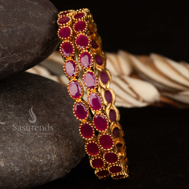 Micro gold plated American diamond bangles adorned with oval ruby stones and glittering accent stones – a rich and festive traditional jewellery design for graceful ethnic styling by Sasitrends