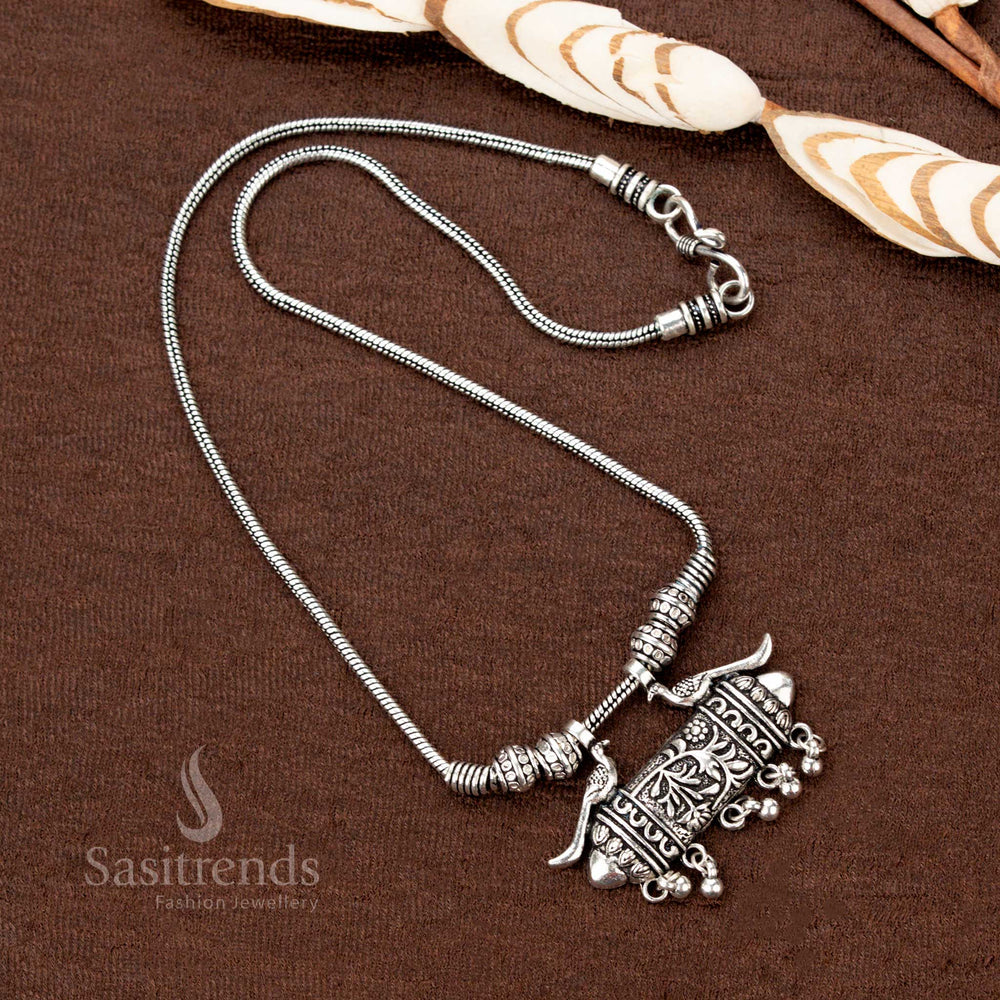 Heritage-inspired oxidised silver necklace featuring regal twin peacock motifs with a bold tribal engraved tube pendant—an antique-style Indian jewellery masterpiece perfect for traditional festivities - Sasitrends