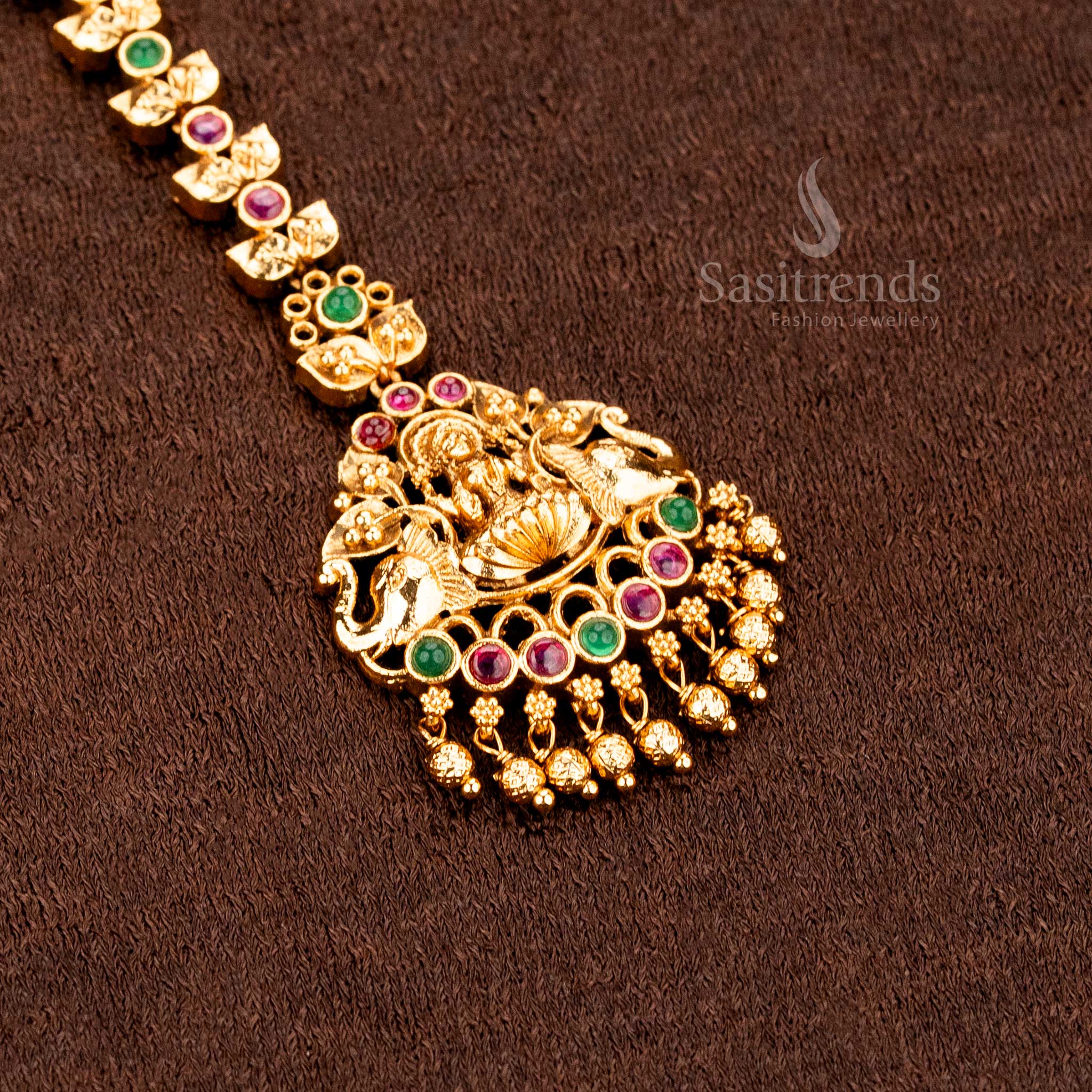Heritage inspired matte gold Lakshmi and peacock mango design tikka featuring elegant AD stone detailing and classic ethnic jewellery charm -sasitrends