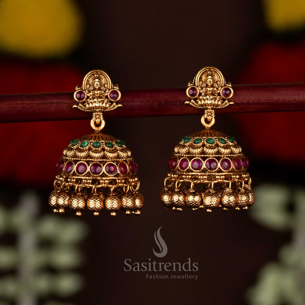 Gorgeous ruby-green divine temple matte gold plated Lakshmi heritage jhumka earrings with ghungroo drops, designed for festive saree wear and vibrant ethnic charm by Sasitrends