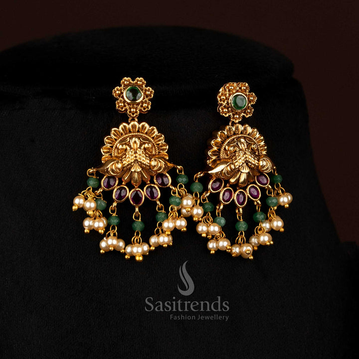 Luminous ruby-green matte gold plated floral dual peacock earrings adorned with pearl charms, designed to wear for festive occasions and temple gatherings – Sasitrends