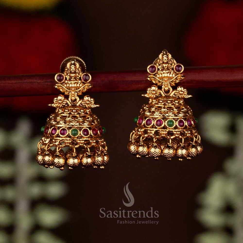 Charming ruby-green temple matte gold plated Lakshmi motif floral jhumka earrings with ghungroo drops, perfect for festive saree wear and radiant traditional occasions by Sasitrends
