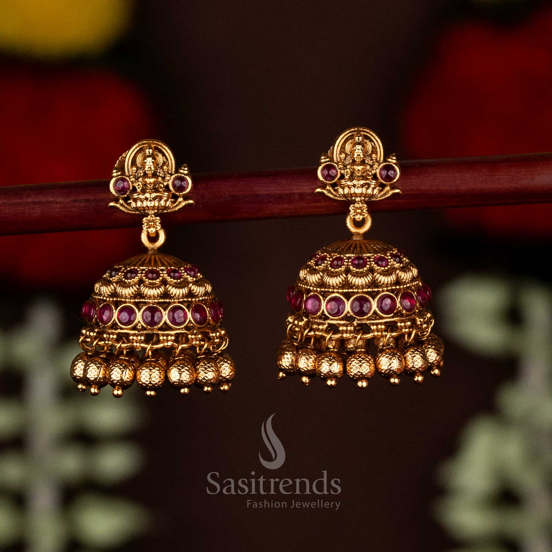 Radiant ruby divine temple matte gold plated Lakshmi heritage jhumka earrings with ghungroo drops, perfect for traditional festive wear and timeless cultural elegance by Sasitrends