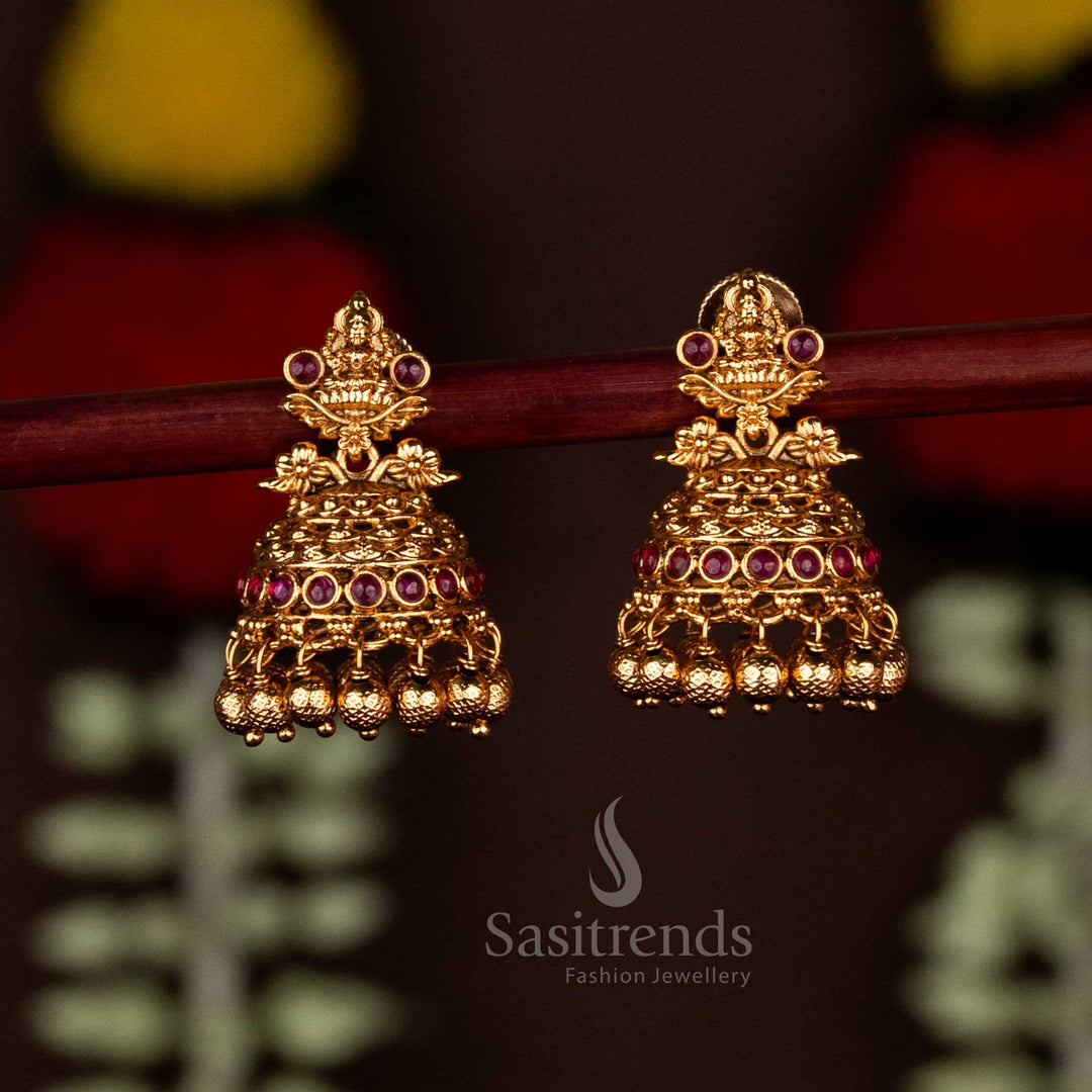 Ruby premium temple matte gold plated Lakshmi motif floral jhumka earrings with ghungroo drops, radiating festive elegance and crafted for graceful traditional wear by Sasitrends