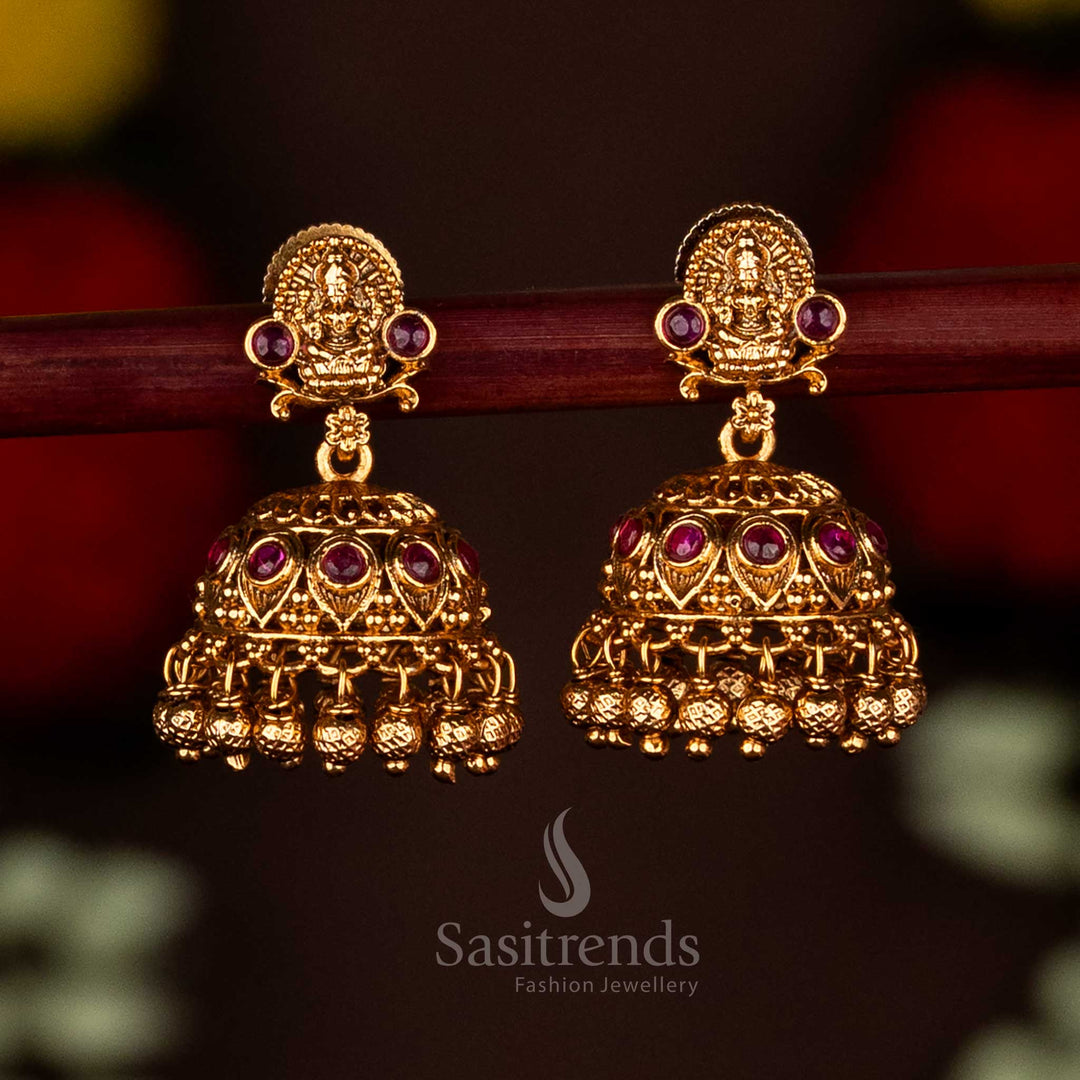 Beautiful ruby matte gold plated Lakshmi motif temple jhumka earrings featuring ghungroo drops, ideal for cultural occasions and celebrations by Sasitrends