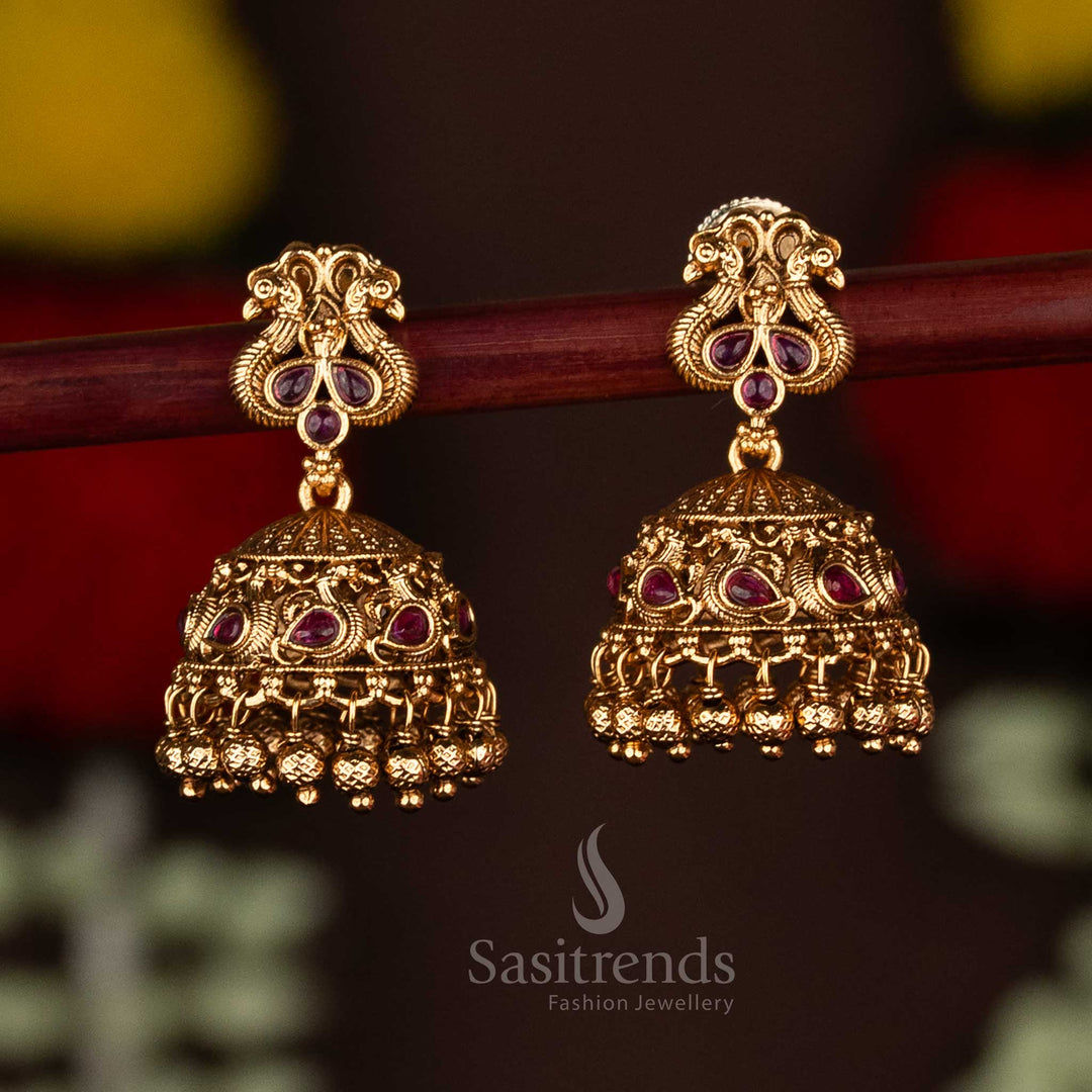 Exquisite ruby temple matte gold plated peacock jhumka earrings adorned with ghungroo drops, radiating festive elegance and premium artistry for saree wear by Sasitrends