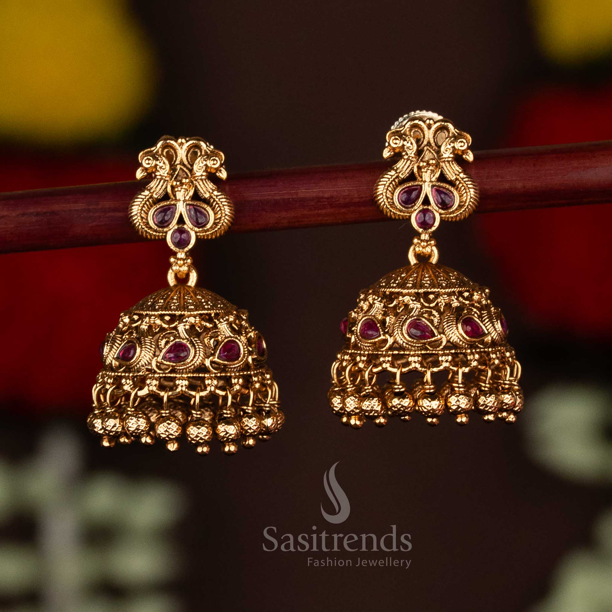 Exquisite ruby temple matte gold plated peacock jhumka earrings adorned with ghungroo drops, radiating festive elegance and premium artistry for saree wear by Sasitrends
