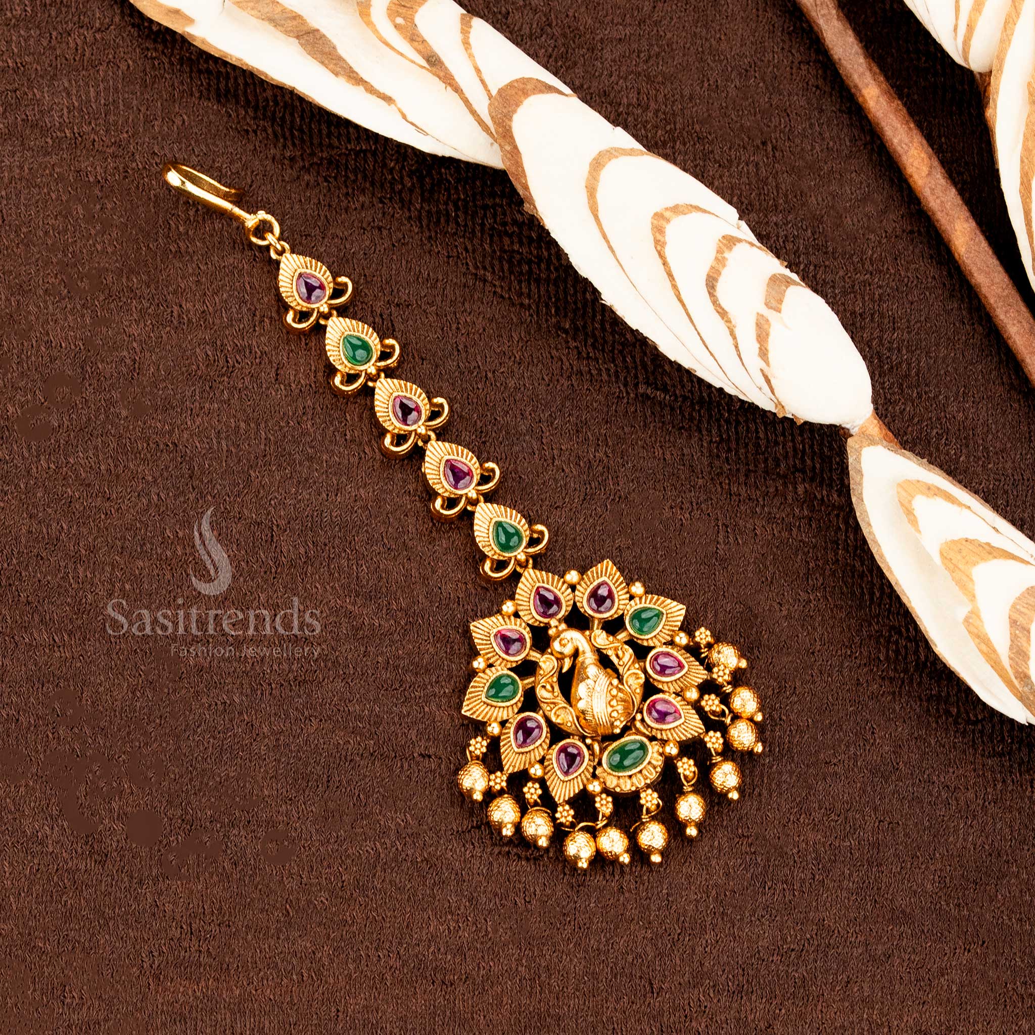 Matte gold Lakshmi peacock mango floral tikka with fine AD embellishments, adding pure wedding jewellery charm and traditional spirit -sasitrends
