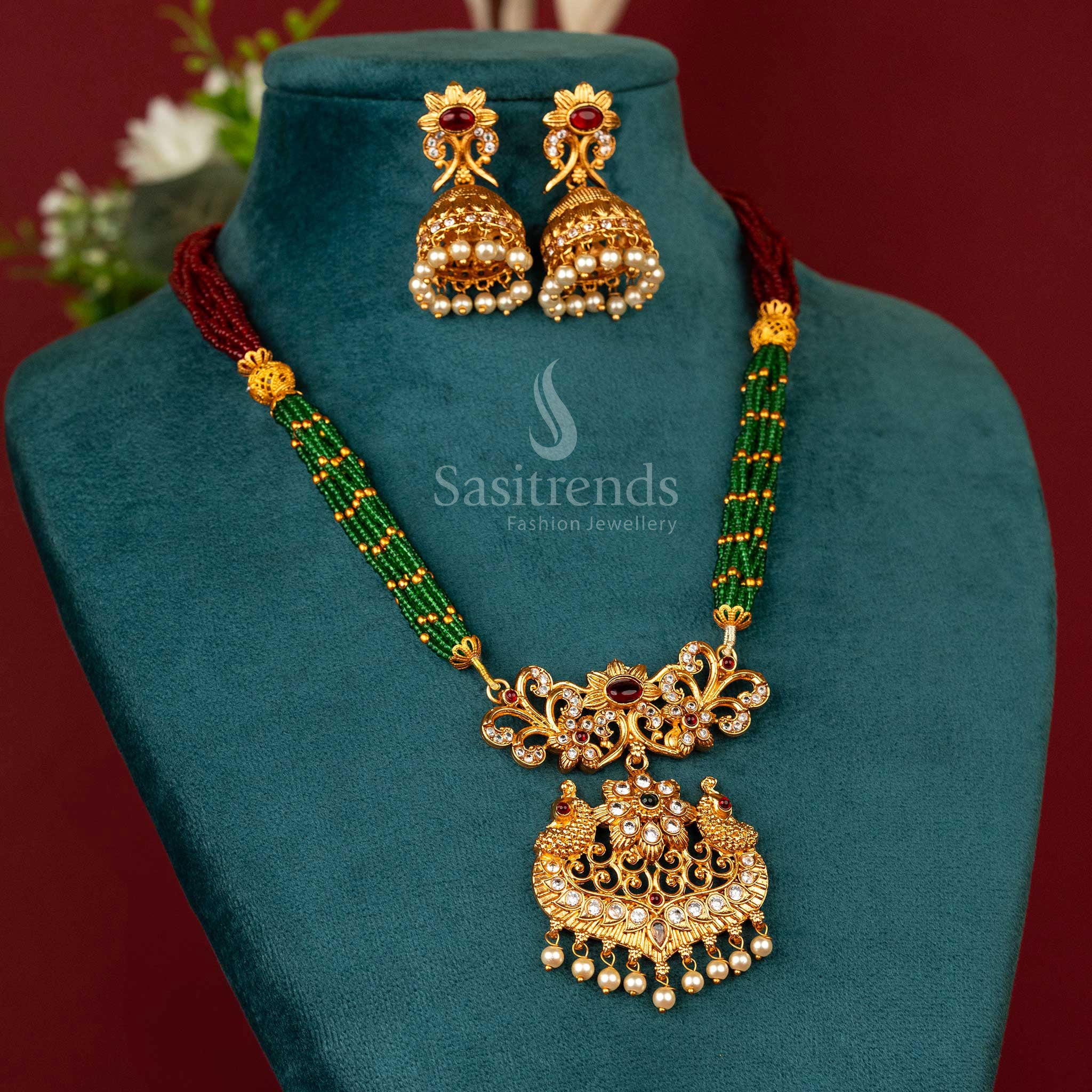 Matte gold plated necklace with a royal peacock pendant and contrasting ruby-green beads – a vibrant festive pick for traditional ensembles – Sasitrends