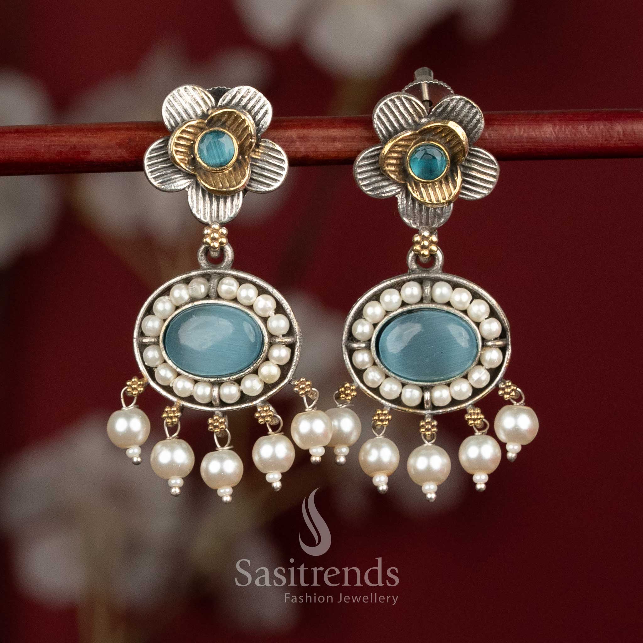 Radiant oxidised silver floral stud earrings adorned with sky-blue Monalisa stones, sculpted floral patterns and clustered pearl drops for sophisticated festive wear - Sasitrends