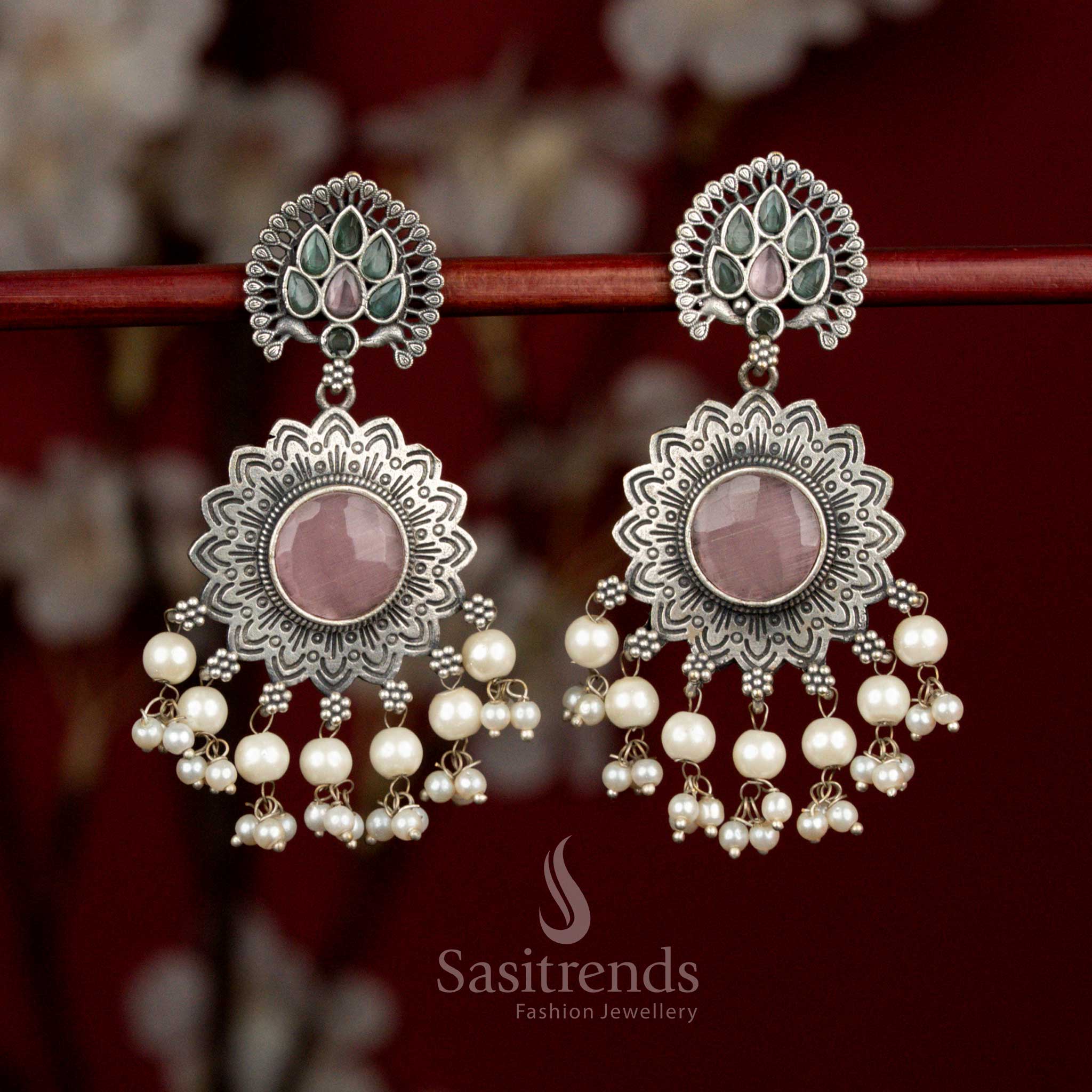 Antique oxidised silver earrings highlighted with pink mint Monalisa stones, dual tone peacock sun floral motif and pearl drops for elegant parties - Sasitrends