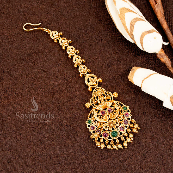 Ethnic matte gold Lakshmi peacock tikka featuring shimmering AD stones and stunning traditional wedding jewellery glam -sasitrends