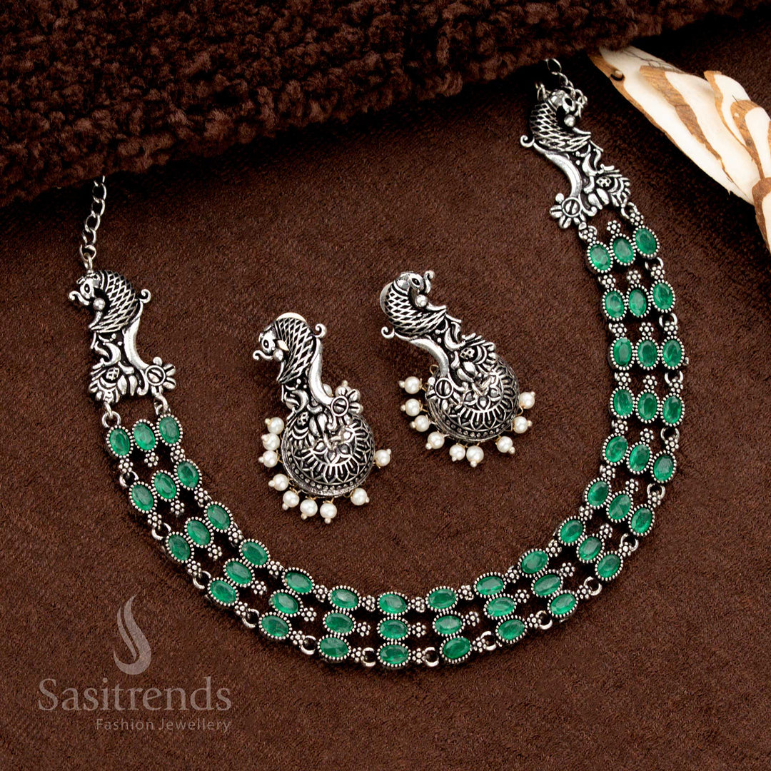 Elegant three-layered oxidised necklace jewellery set adorned with vibrant green stone highlights and traditional pearl jhumka—perfect for boho chic ethnic style with a touch of rustic heritage - Sasitrends