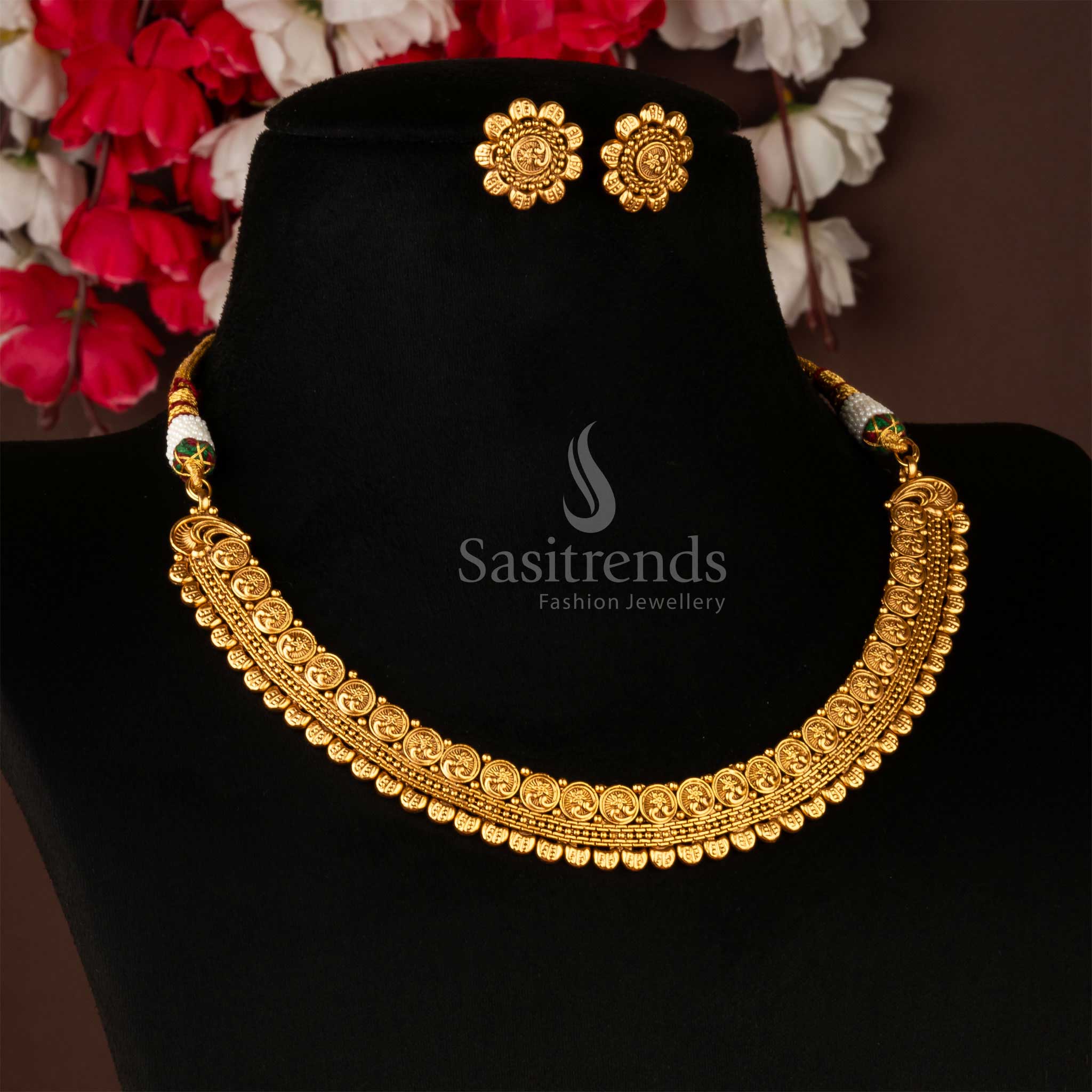Antique gold-plated brass necklace and earrings set with traditional floral design on a black display stand - Sasitrends