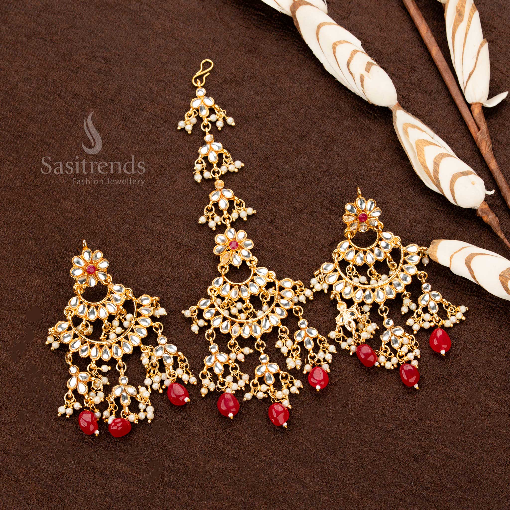 Exquisite antique gold plated tikka and earrings set featuring a crescent structure, intricate floral motif, and delicate pearl drops, designed in a royal red shade for an opulent ethnic bridal style - Sasitrends