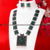 Oxidised German Silver Necklace with Captivating Green Stones Pendant and Harmonizing Pearl Earrings.