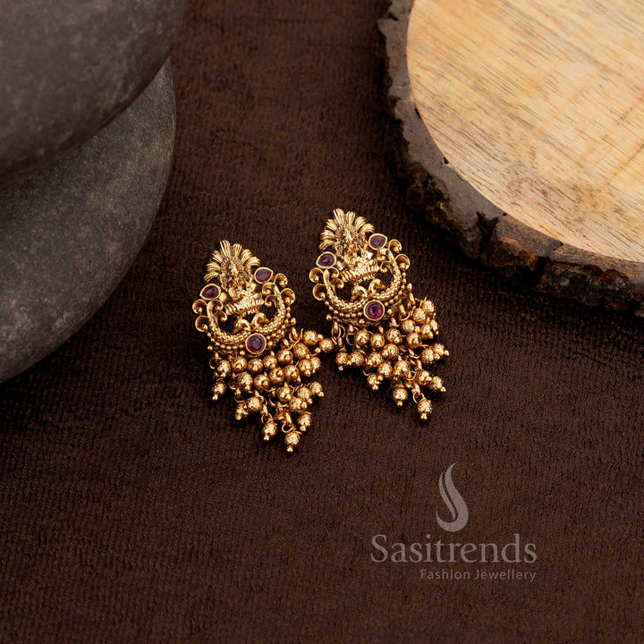 Elegant matte gold plated temple earrings showcasing Lakshmi and peacock artistry embellished with ruby stones and Gold beads – Sasitrends