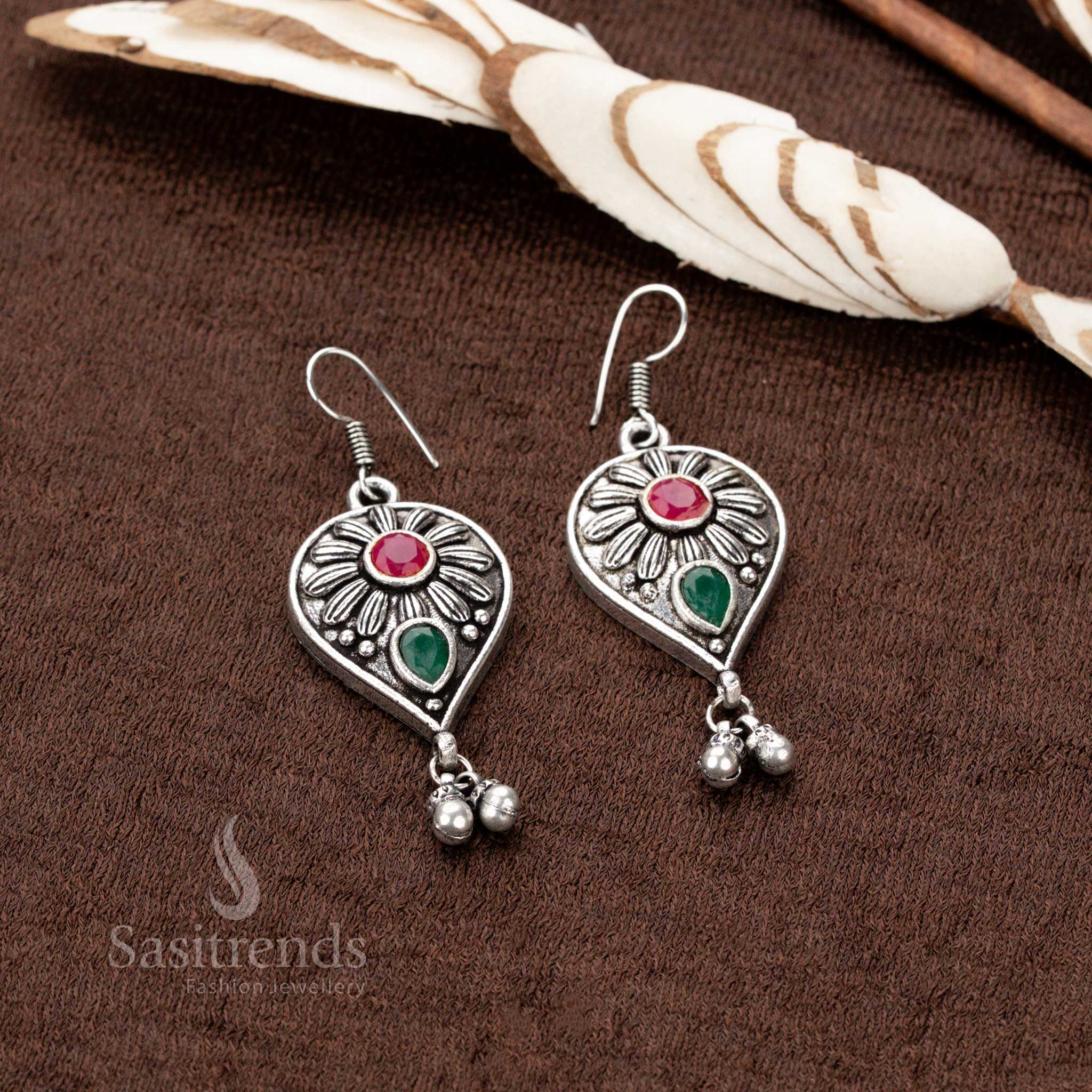 Antique oxidised silver earrings, adorned with ruby-green stone highlights, intricately crafted peacock motifs, a floral centerpiece, and teardrop dangles, perfect for ethnic jewellery lovers - Sasitrends