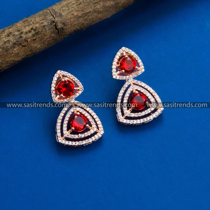 Party wear rose gold earrings showcasing an exquisite floral design, American Diamonds, and vibrant red stones