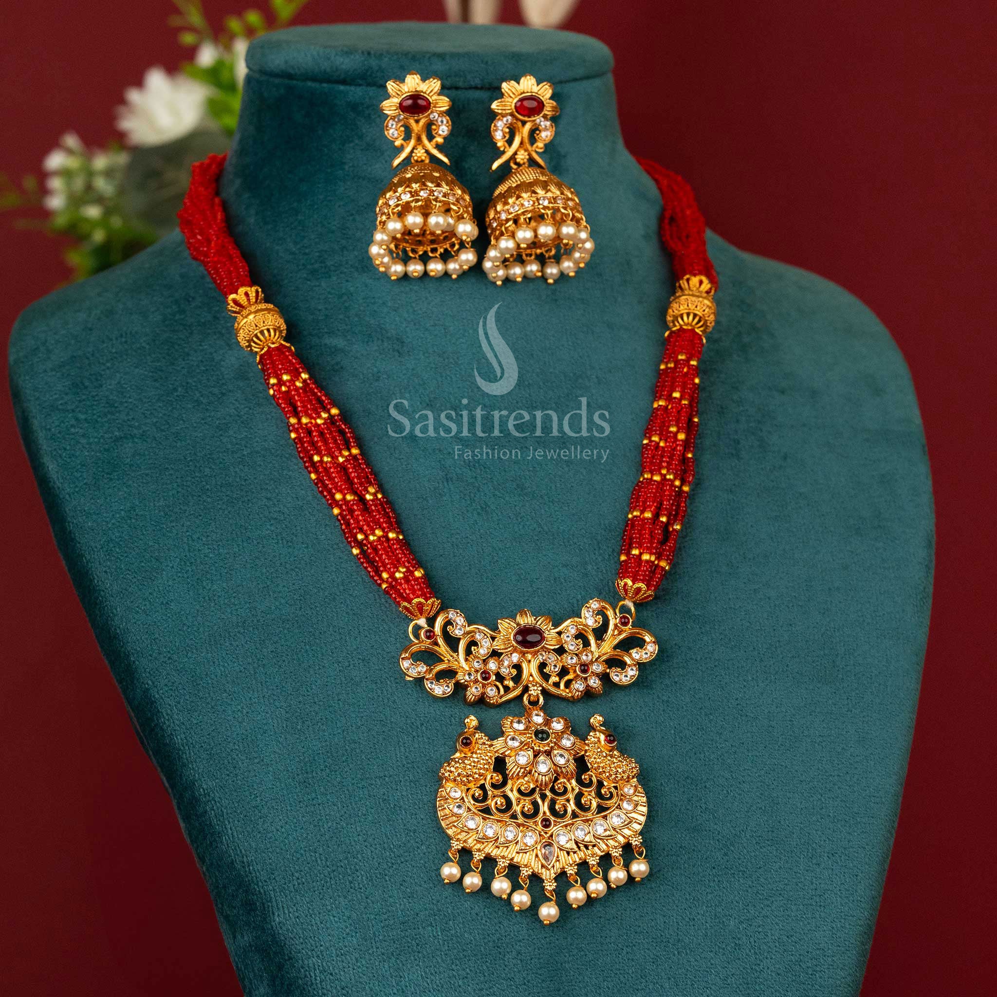 Ethnic matte gold plated necklace jewellery with deep red beads, classic chain work and a vibrant multitone peacock pendant – a radiant piece for festive occasions – Sasitrends
