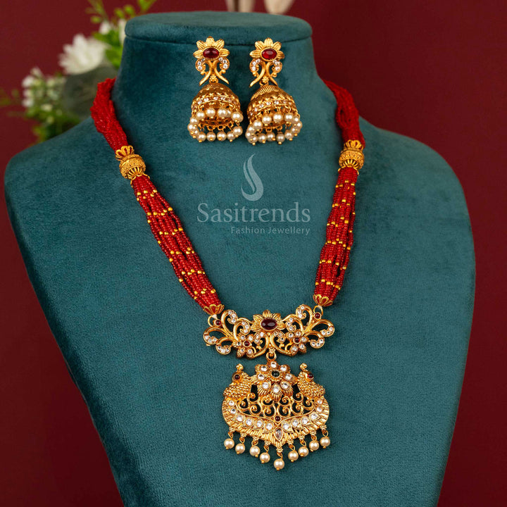 Ethnic matte gold plated necklace jewellery with deep red beads, classic chain work and a vibrant multitone peacock pendant – a radiant piece for festive occasions – Sasitrends