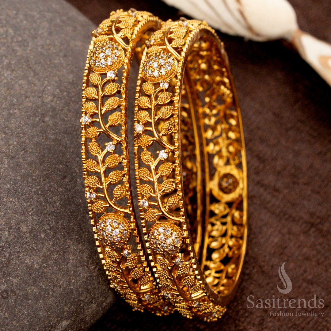 Stunning handcrafted matte gold bangles adorned with white AD stones in a leaf pattern, ideal for ethnic and bridal ensembles - Sasitrends