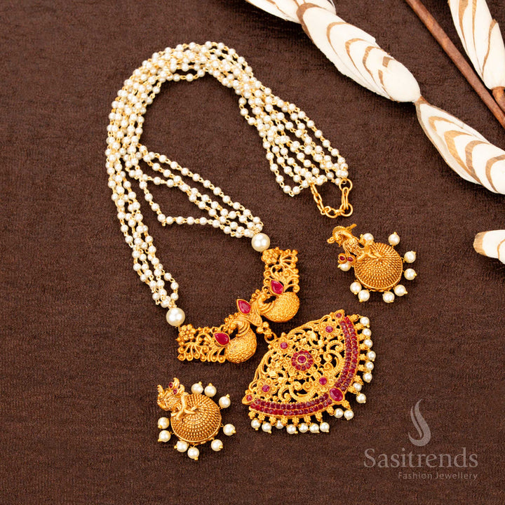 Traditional peacock temple necklace set crafted in matte gold, showcasing dual-tone ruby ZX stonework and ornate pearl jhumkas—an ethnic floral jewellery piece that radiates festive cultural bloom - Sasitrends