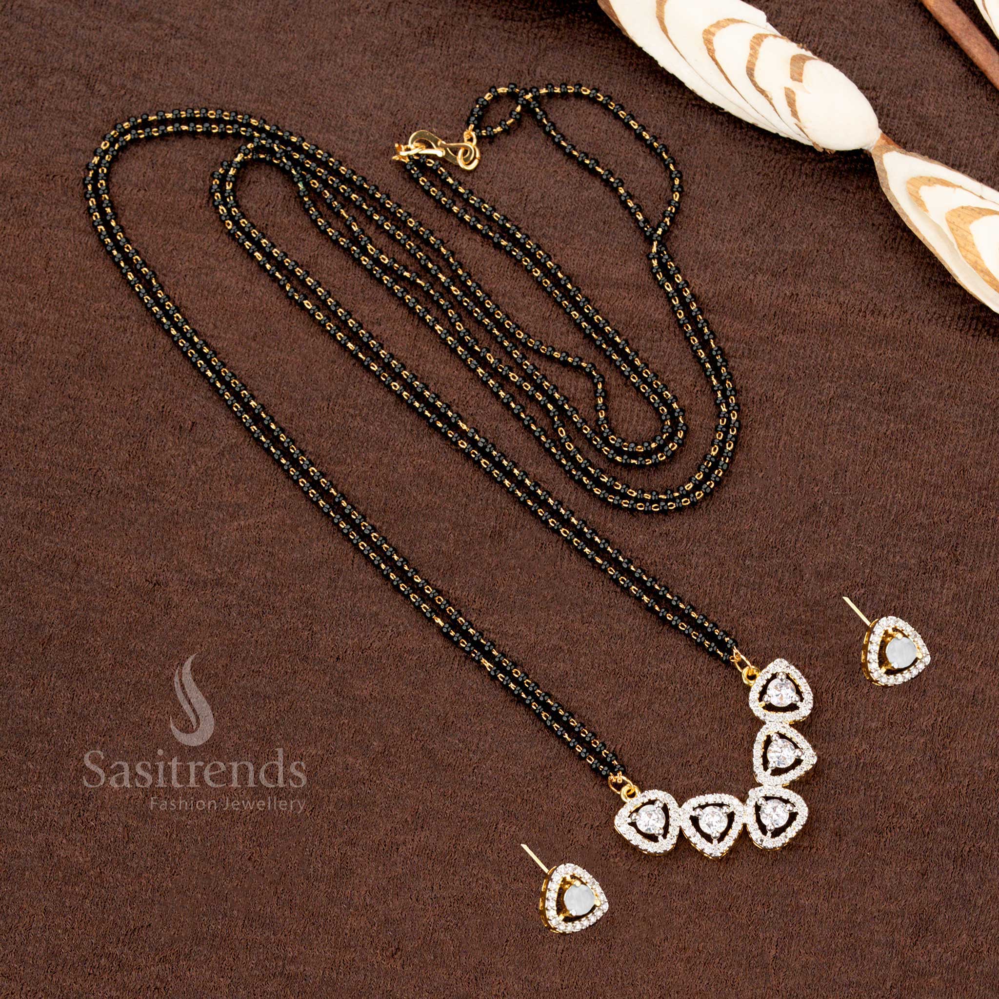 Dazzling white AD pendant set with a tri-petal drop motif, paired with a micro gold plated Mangalsutra chain and matching earrings, a premium ethnic jewellery piece - Sasitrends