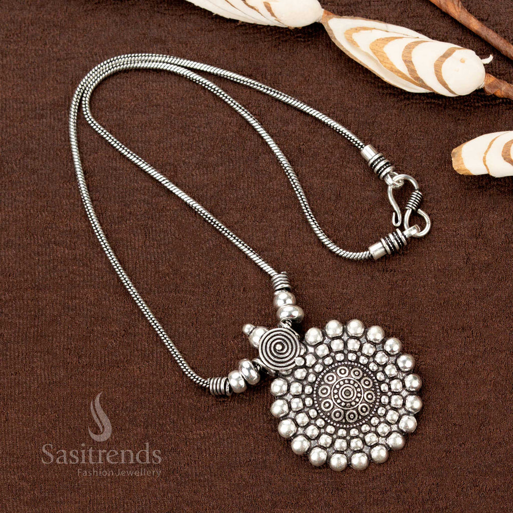 Cultural essence captured in an oxidised silver necklace featuring a symbolic round spiral and beaded floral mandala pendant—a vibrant piece of Navaratri jewellery rooted in traditional Indian design - Sasitrends