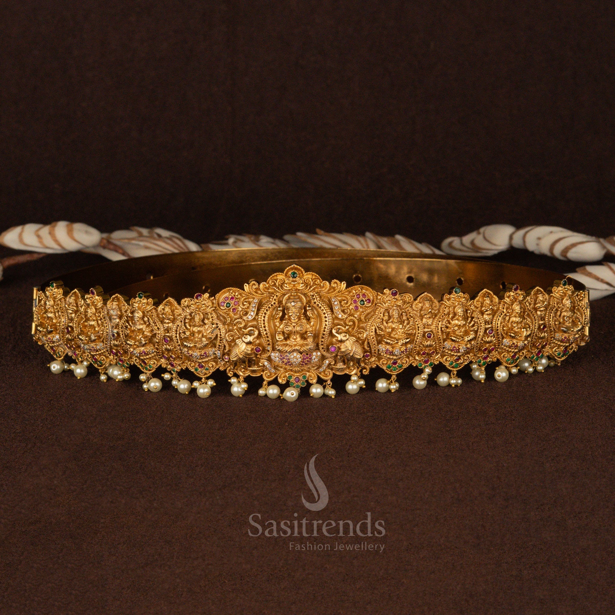Majestic bridal hip belt in matte gold plating, featuring a divine Lakshmi centerpiece with detailed peacock and elephant motifs, adorned with radiant white pearl hangings - Sasitrends