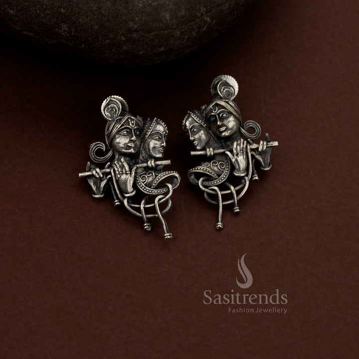 Devotional Oxidised Silver Plain Radha Krishna Sculptural Drop Earrings Depicting Eternal Love with Flute Motif and Flowing Art Form Structure