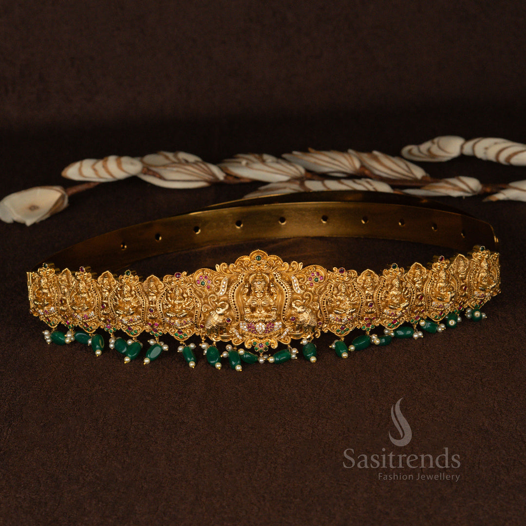 Elegant gold-plated Lakshmi waist chain with temple-style peacock and elephant embellishments, completed with beautiful green pearl drops for an ethereal bridal statement - Sasitrends